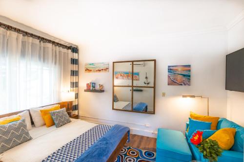ein Schlafzimmer mit einem Bett, einem Sofa und einem Spiegel in der Unterkunft Lemon Cottage - At Orange Hill in Nassau
