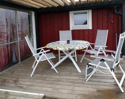 a patio table and chairs on a deck at 1C, Första parkett, 50m till badstrand in Byxelkrok