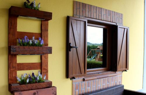 a window with purple flowers on the side of a wall at Quinta Sobral Prestige - Rustic House in Sobral de Monte Agraço
