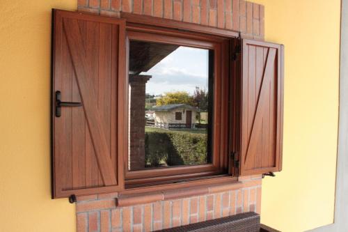 a window with a wooden door on a wall at Quinta Sobral Prestige - Rustic House in Sobral de Monte Agraço