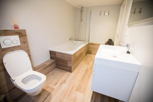 y baño con aseo, lavabo y bañera. en appartement - sauna - natuur - Utrecht en Soest