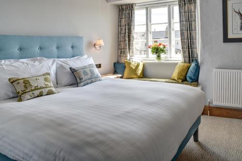 a large white bed in a room with a window at Barn Owl Inn in Newton Abbot