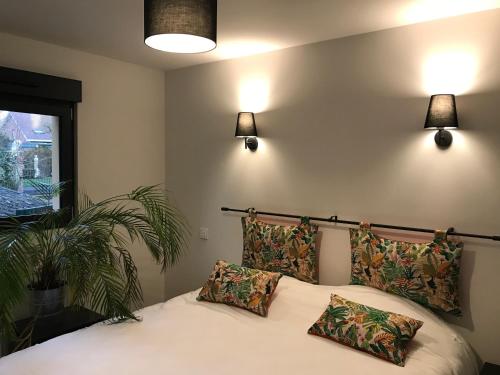 - une chambre avec un lit avec deux oreillers et deux lumières dans l'établissement Gites du bien-hêtre, à Saint-Amand-les-Eaux