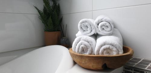 uma tigela de madeira cheia de toalhas na casa de banho em Pension Bakema Ameland em Nes