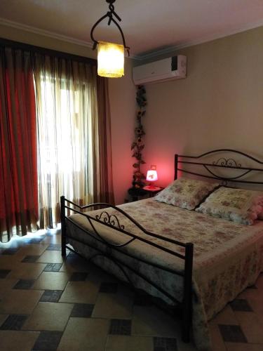 a bedroom with a bed and a lamp and a window at DOWN TOWN LUXURY Apartment in Sarandë