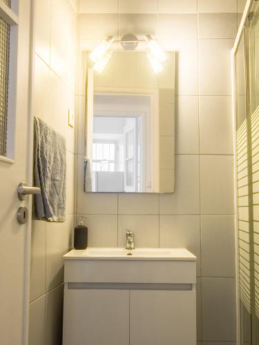 a bathroom with a sink and a mirror at Alagoa Terrace Guesthouse in Faro