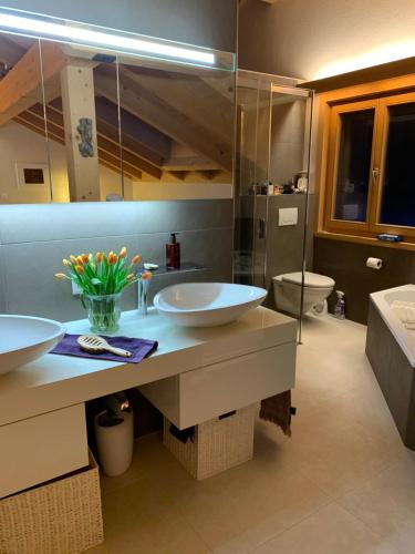 a bathroom with two sinks and a toilet at Pegasus in Zweisimmen