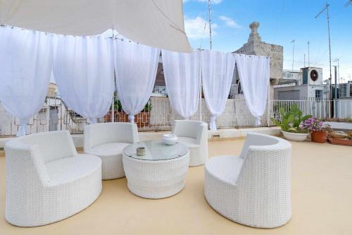 a group of white chairs and a table on a roof at Amoredimare Casa Vacanze in Polignano a Mare