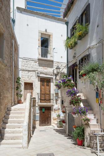 an alley with stairs and flowers in a building at Amoredimare Casa Vacanze in Polignano a Mare