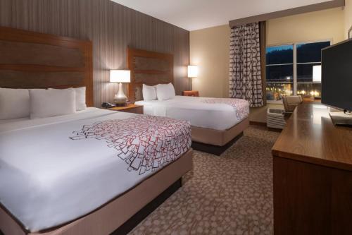 a hotel room with two beds and a desk at La Quinta by Wyndham Durango in Durango