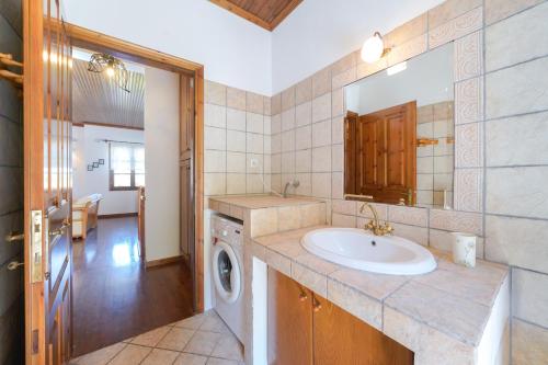 a bathroom with a sink and a washing machine at Villa Nina in Panagia