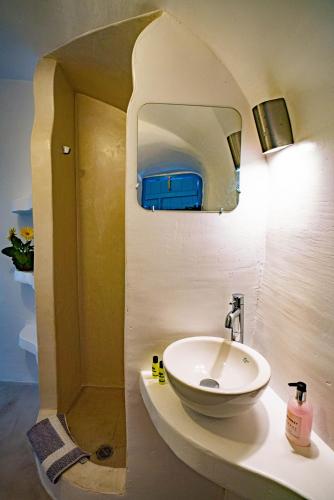 a bathroom with a sink and a mirror at Bonita Santorini Cave in Éxo Goniá
