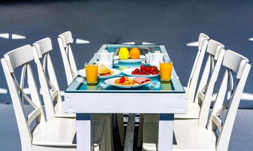 a table with plates of food and orange juice at Bonita Santorini Cave in Éxo Goniá