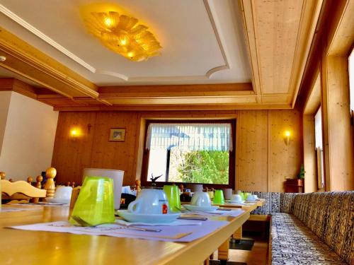 a dining room with a long table with chairs at Hotel B&B Lorenzini Ski in Selva di Cadore