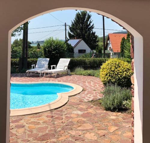 a patio with two chairs and a swimming pool at ALPHA in Badacsonytördemic