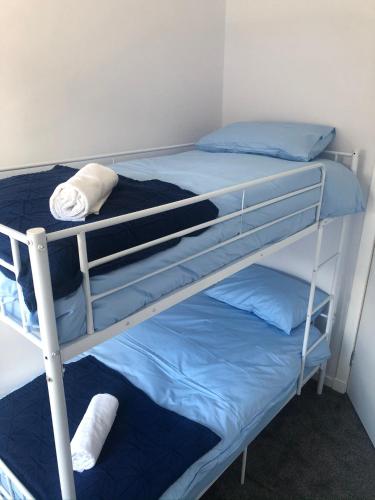 two bunk beds in a room with blue pillows at Amazing Alps and Loch views - HOT TUB and pet friendly in Arrochar