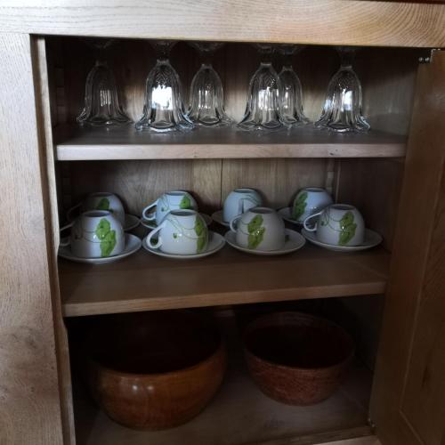 a cupboard with plates and cups and glasses at Ô Rethel Jacuzzi, Gîte Ardennes in Rethel