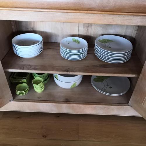 a cabinet filled with plates and bowls at Ô Rethel Jacuzzi, Gîte Ardennes in Rethel