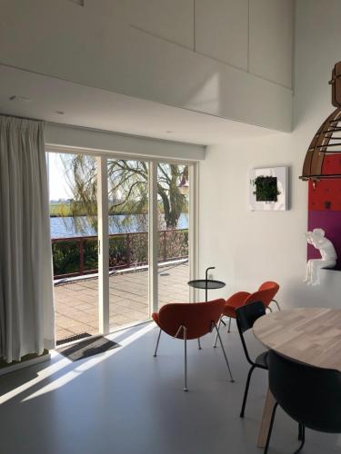 une salle à manger avec une table, des chaises et une grande fenêtre dans l'établissement Loft Bed and Breakfast, à Grou