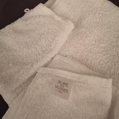 a pile of white towels with a tag on it at Ô Rethel Jacuzzi, Gîte Ardennes in Rethel