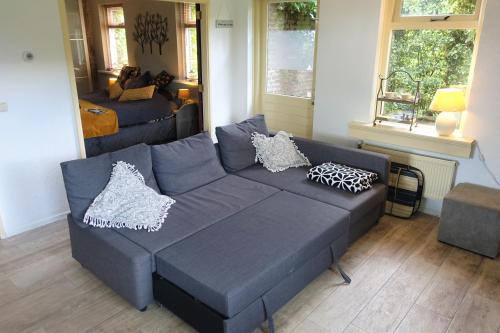 salon z niebieską kanapą i łóżkiem w obiekcie De Aardigeyt w mieście Giethoorn