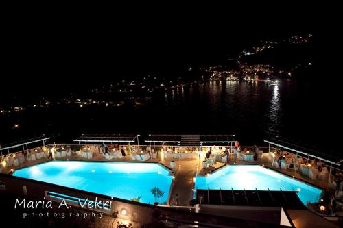 a cruise ship deck with a pool at night at Aegialis Hotel & Spa in Aegiali