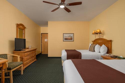 a hotel room with two beds and a flat screen tv at Chena Hot Springs Resort in Chena Hot Springs