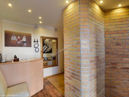 a brick wall next to a bar in a salon at Pensjonat U Janiny Bolesławiec in Bolesławiec