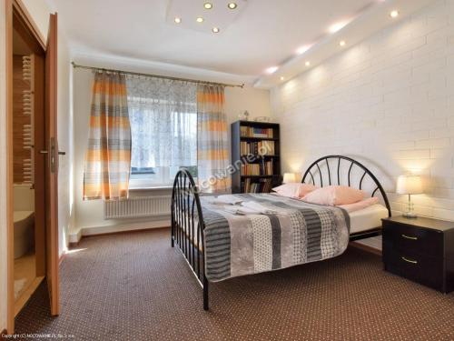 a bedroom with a bed and a window at Pensjonat U Janiny Bolesławiec in Bolesławiec