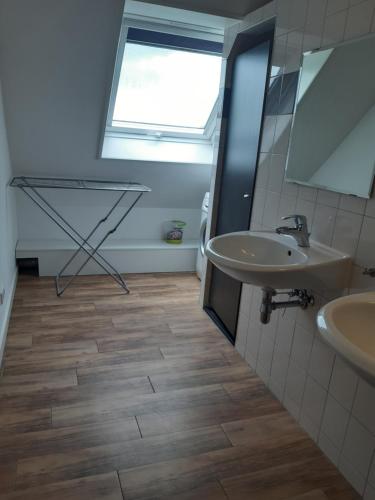 a bathroom with two sinks and a window at Auf dem Lande in Weener