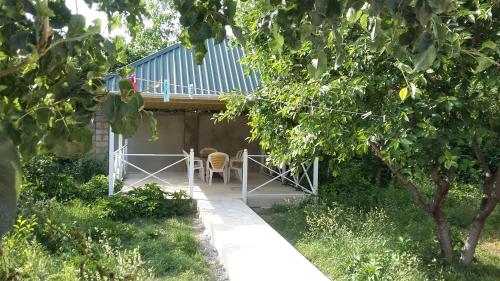 a house with a balcony with a table and a chair at Family holiday home. in Qusar