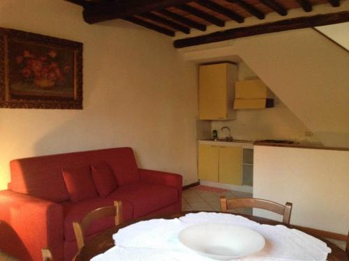 a living room with a red couch and a table at Agriturismo La Selva in Siena