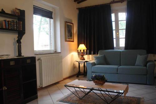 a living room with a blue couch and a table at Agriturismo La Selva in Siena