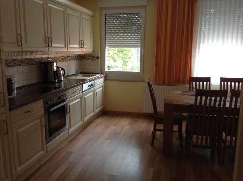 a kitchen with white cabinets and a table and a window at KRAL - Residenz Erlangen in Erlangen
