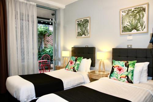 a hotel room with two beds and a window at Mariners Court Hotel Sydney in Sydney