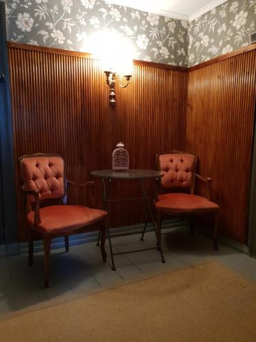 two chairs and a table in a room with wood paneling at Renkitupa in Raahe