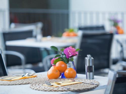 uma mesa com laranjas e um vaso de flores sobre ela em Fornalutx Petit Hotel - Bed & Breakfast em Fornalutx