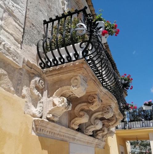 a balcony on the side of a building with flowers at Bed and Breakfast Terra del Sole Ibla in Ragusa