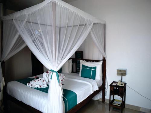 a bedroom with a bed with a canopy at Maru Maru Hotel in Zanzibar City