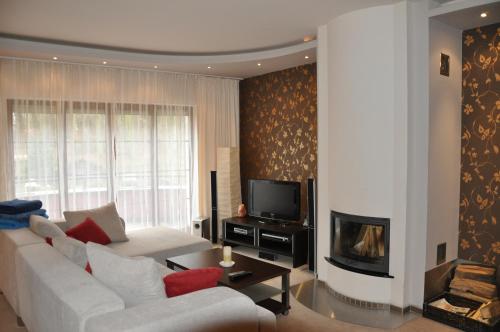 a living room with a white couch and a fireplace at Apartmán Bílá Hora - Roudná in Plzeň