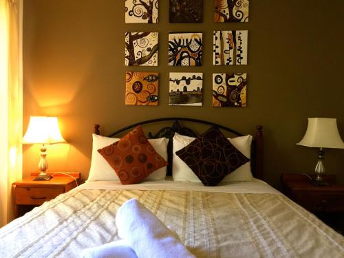 - une chambre avec un lit et des photos sur le mur dans l'établissement Beachend Bicheno, à Bicheno