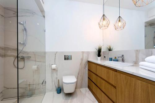a bathroom with a shower and a toilet and a sink at Blue Rentyear Apartments in Gdańsk