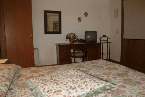 a bedroom with a bed and a desk and a television at Agriturismo La Selva in Siena