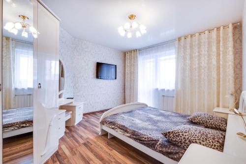 ハバロフスクにあるApartment on Istomina 22aの白いベッドルーム(ベッド1台、テレビ付)