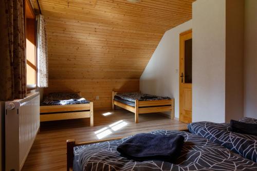 2 Betten in einem Zimmer mit Holzwänden in der Unterkunft Chata Lienka in Lazisko