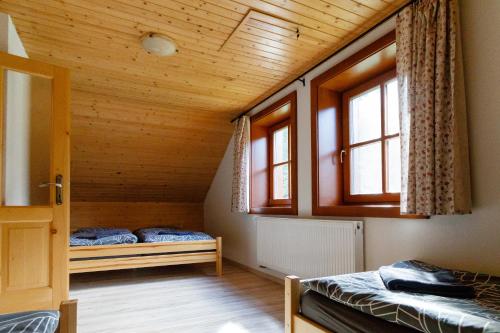 two beds in a room with two windows at Chata Lienka in Lazisko