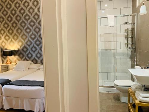 a bathroom with a bed and a toilet and a sink at Super Balmes Guest House in Barcelona