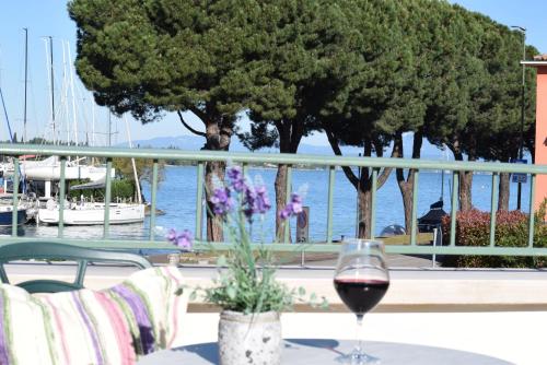 a glass of wine on a table with a view of the water at Albergo Trattoria Fioravante in Peschiera del Garda