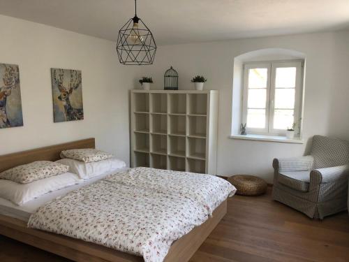 una camera con due letti e una sedia e una finestra di Fancy Luxury Home In Former Tavern a Gmunden