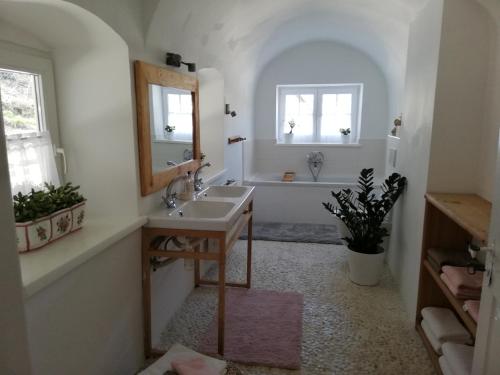 e bagno con lavandino, specchio e vasca. di Fancy Luxury Home In Former Tavern a Gmunden